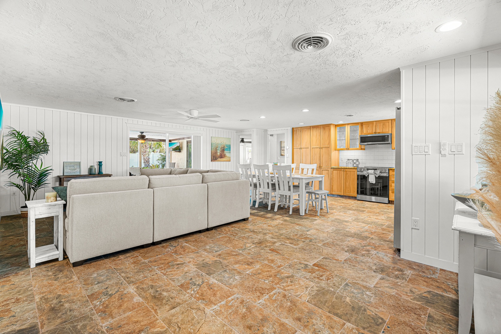 Step into your bright, open living space where the coastal-inspired living room flows seamlessly into the dining area and kitchen. Gather around the large table or relax on the plush sofa, with everything you need just steps away.