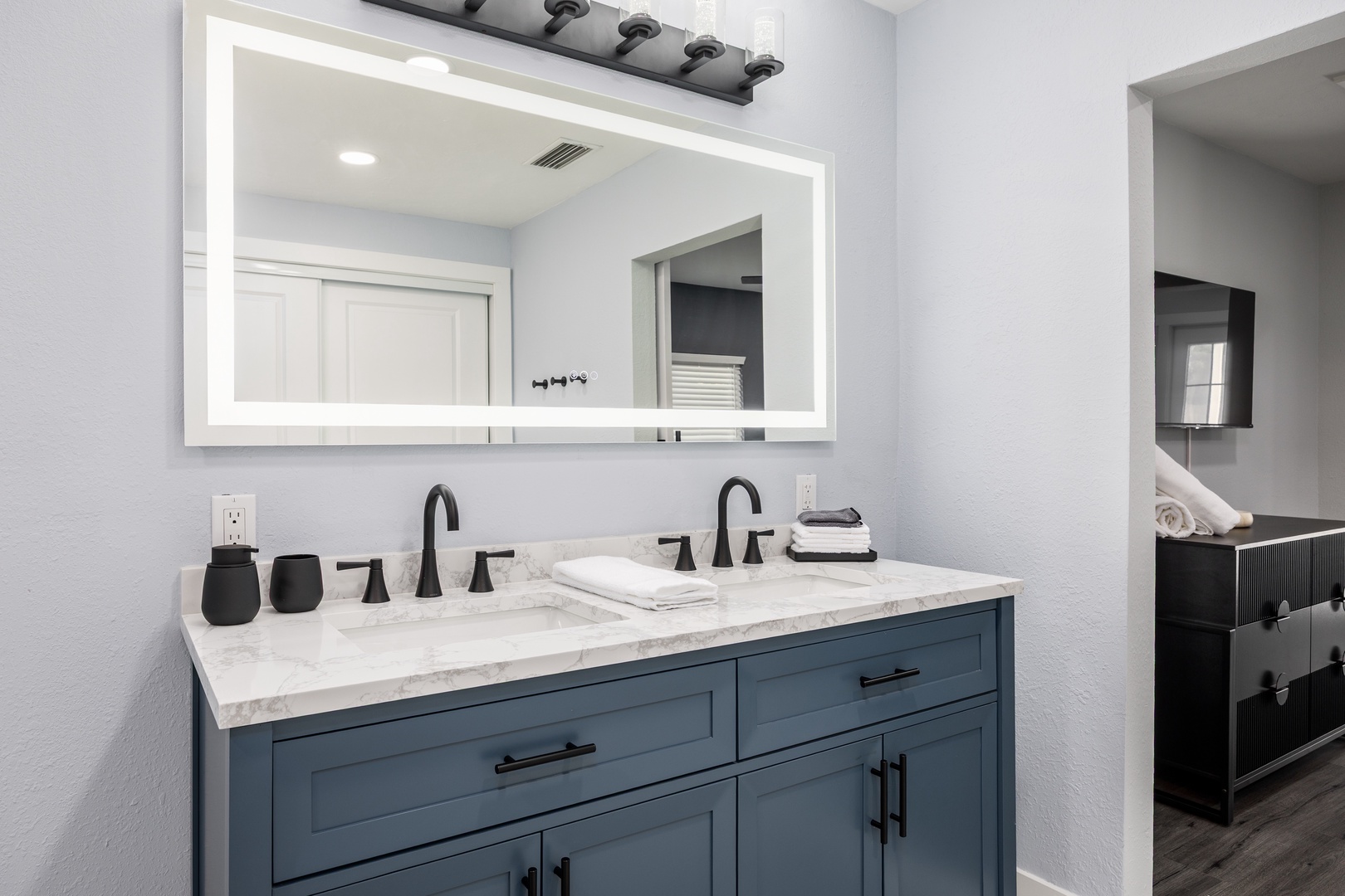 Your stylish double vanity features modern blue cabinetry and elegant marble countertops, perfect for your morning routine together.