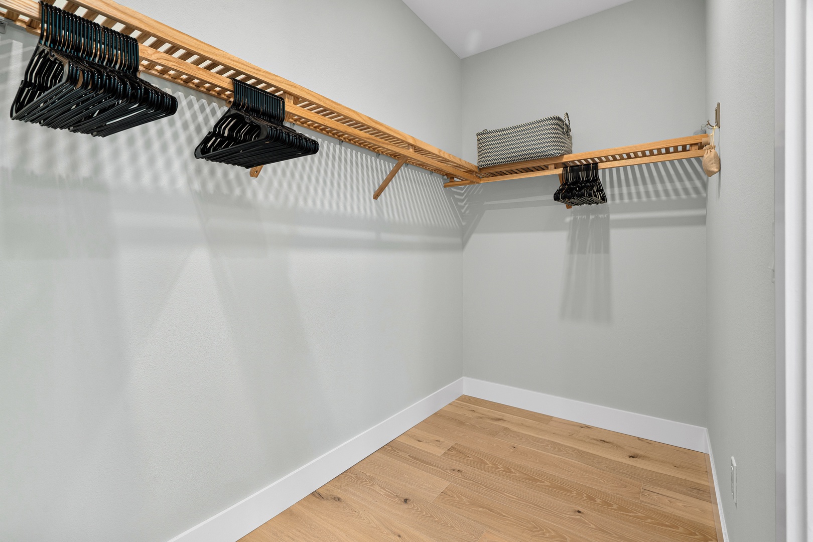 Your walk-in closet features warm wood shelving and plenty of hangers, offering ample space to organize and store your belongings throughout your stay.