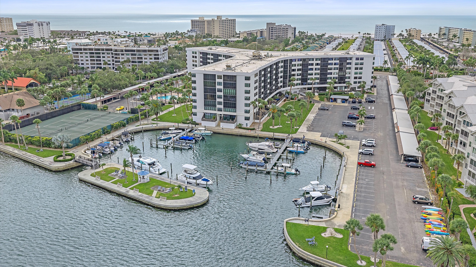 Aerial view of the waterfront property development with marina and surrounding coastal community buildings.