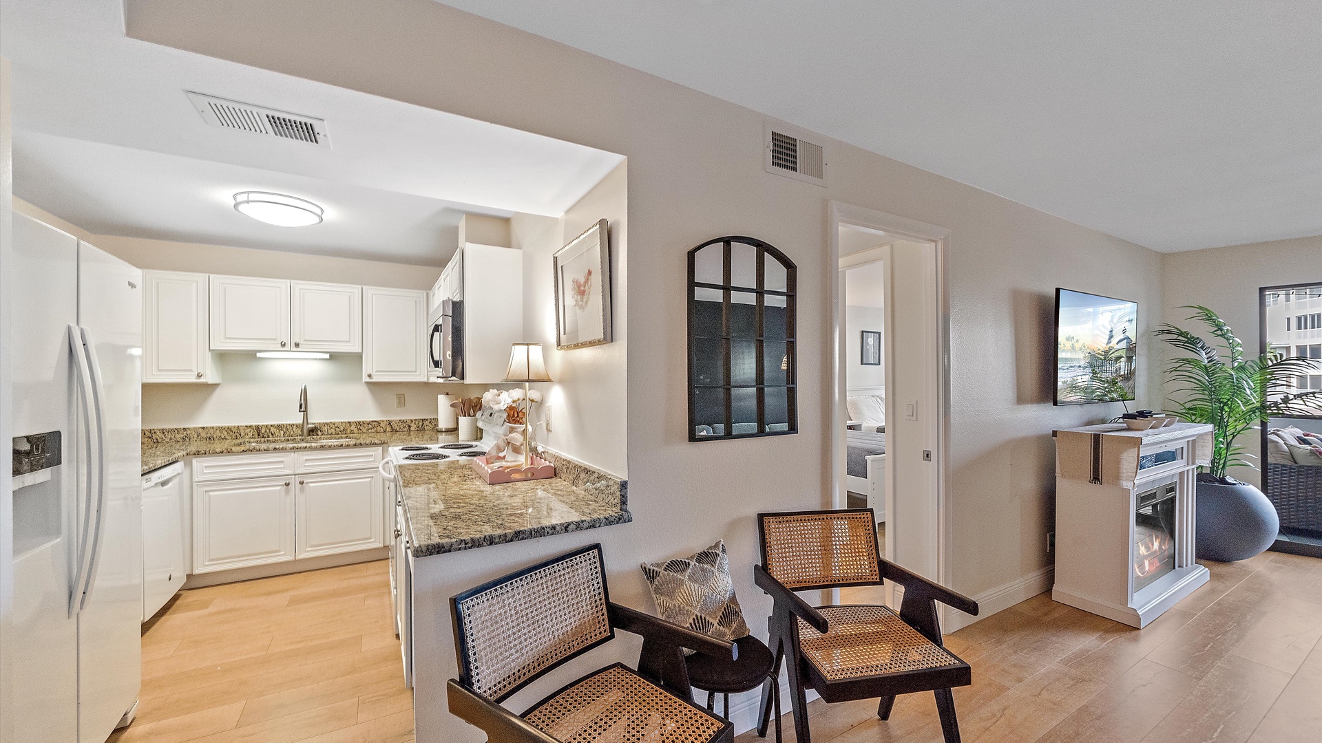Settle into your stylish open-concept living space featuring a fully equipped kitchen with granite countertops, comfortable seating area, and entertainment center for relaxing evenings.