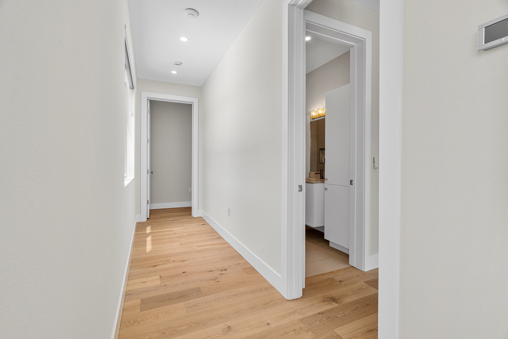 A bright hallway with warm hardwood flooring connects your private spaces, creating a welcoming flow throughout the home.