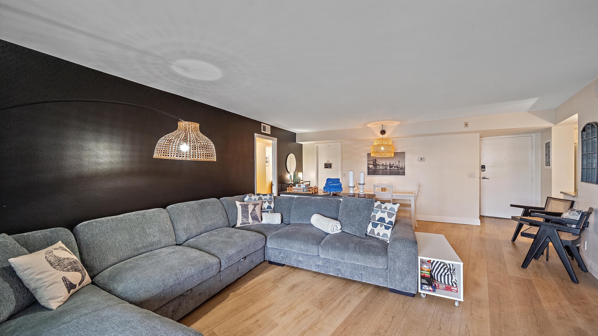 Relax in your spacious living area with comfortable sectional seating, stylish pendant lighting, and warm wood floors that flow into the open dining space.