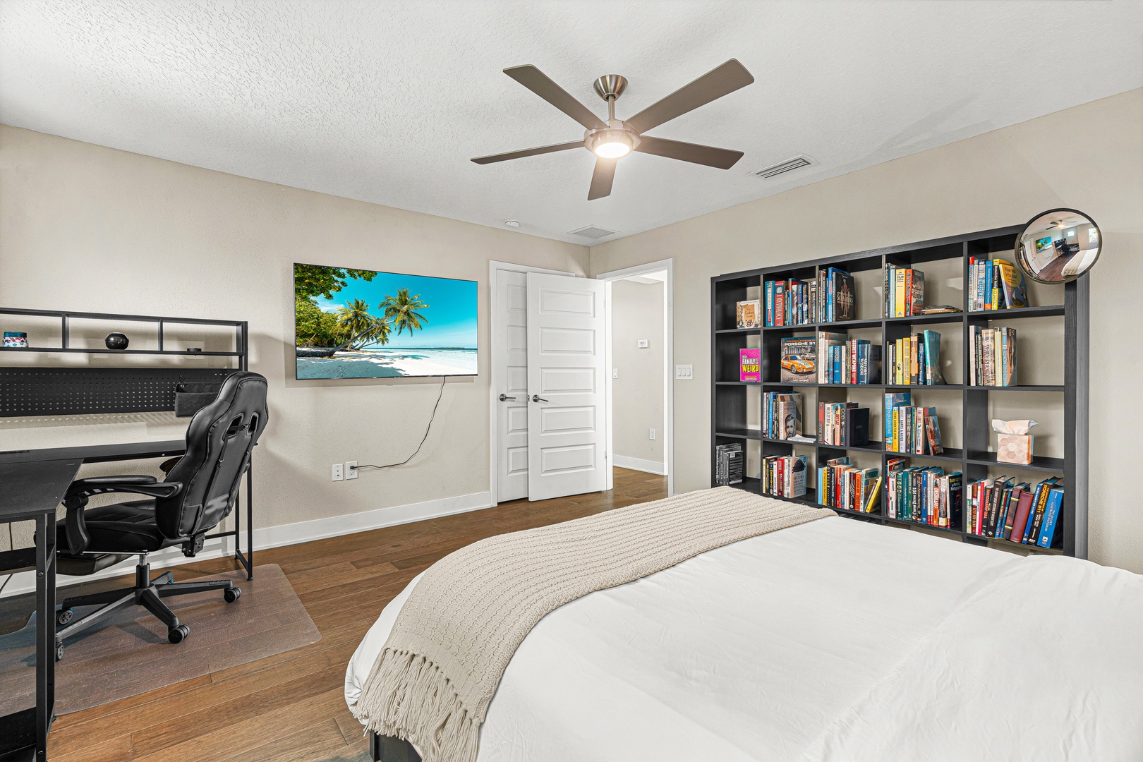 Unwind in your cozy bedroom with hardwood floors, ceiling fan, and a bookshelf stocked with reads. A dedicated workspace keeps you productive, while the soft bedding invites restful nights.