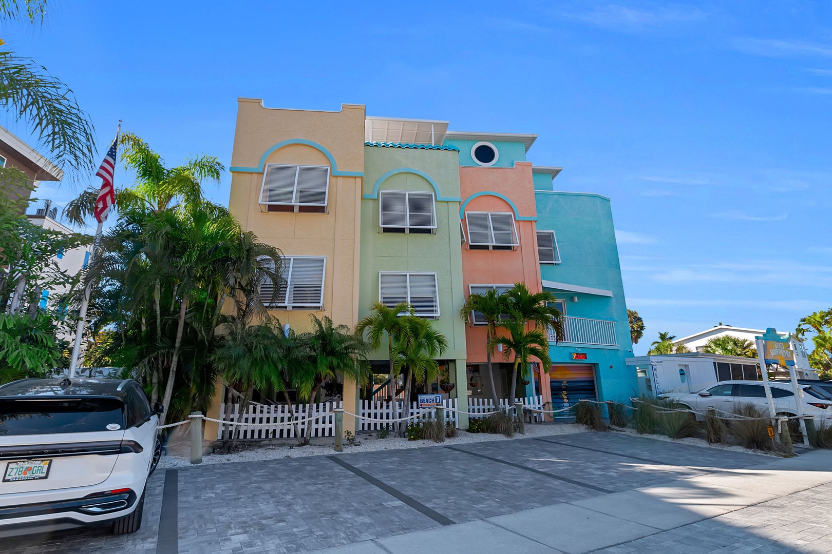 A vibrant, colorful beachside building with cheerful Art Deco architecture, nestled among palm trees with parking just steps from your door.