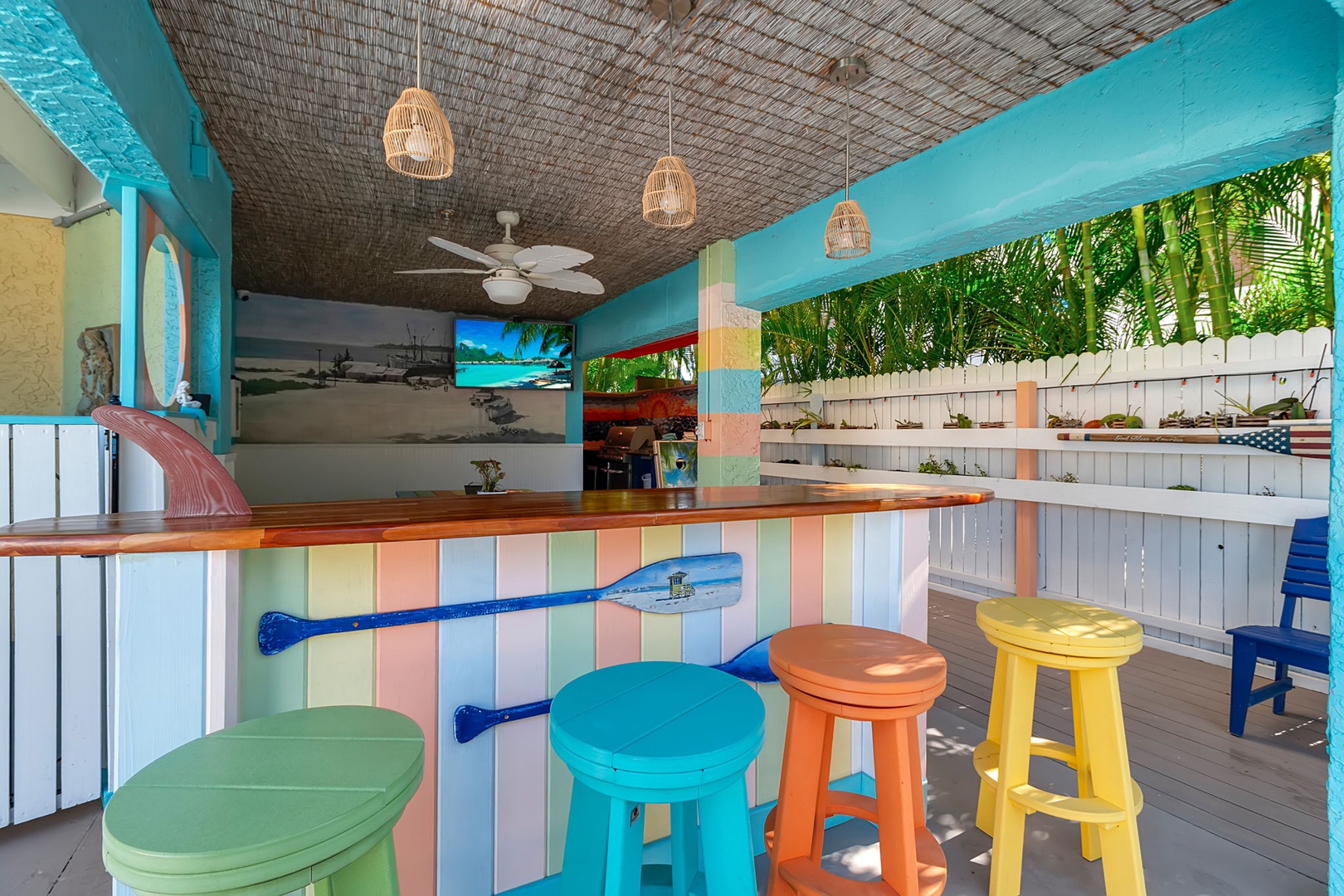 Your own island-style bar with vibrant colors, tropical ceiling fans, and a breezy open-air design. Colorful stools invite you to relax with a cold drink as natural light filters through lush greenery.