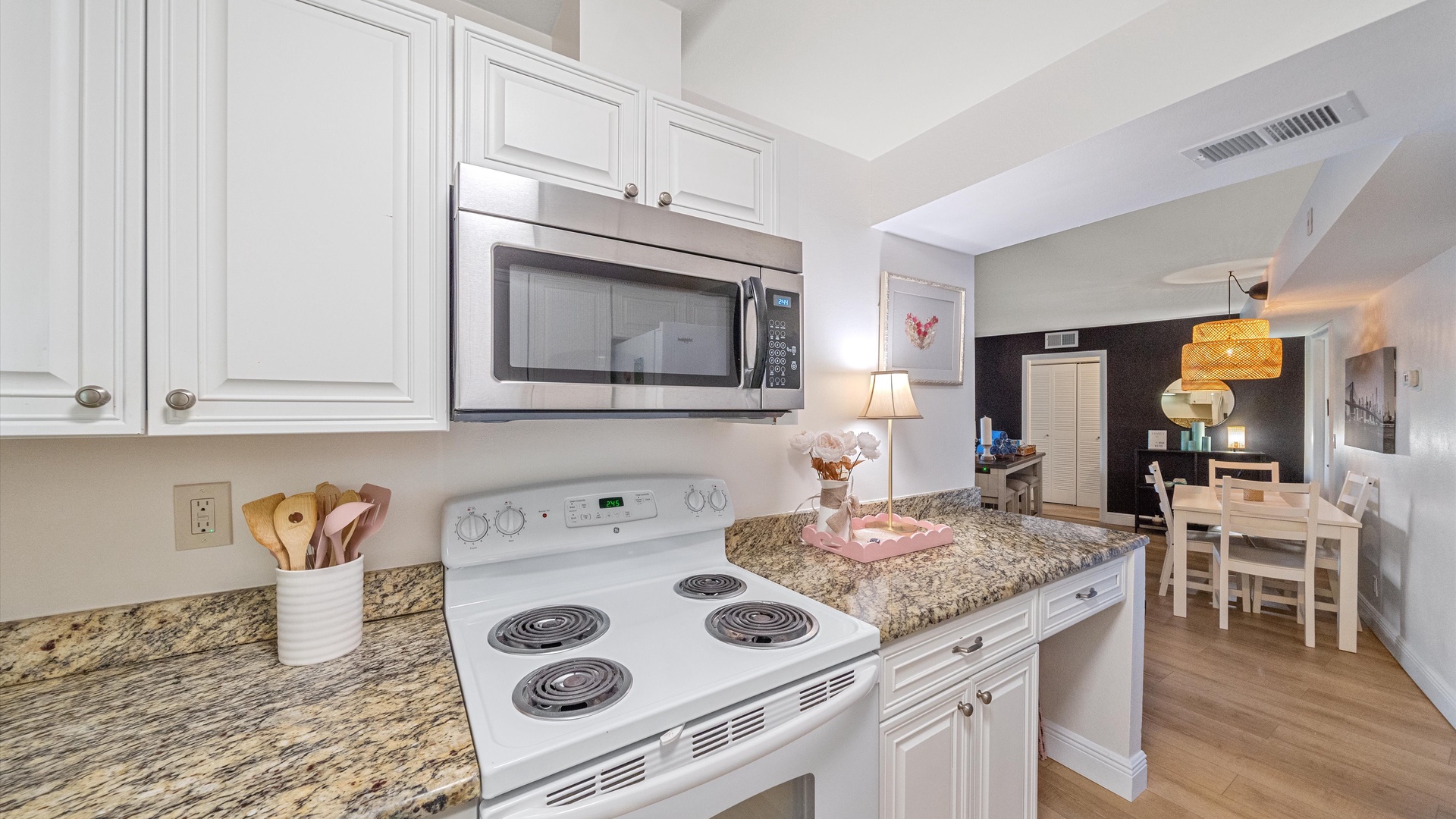 Your fully equipped kitchen features granite countertops, white cabinetry, and modern appliances - perfect for preparing meals during your stay.
