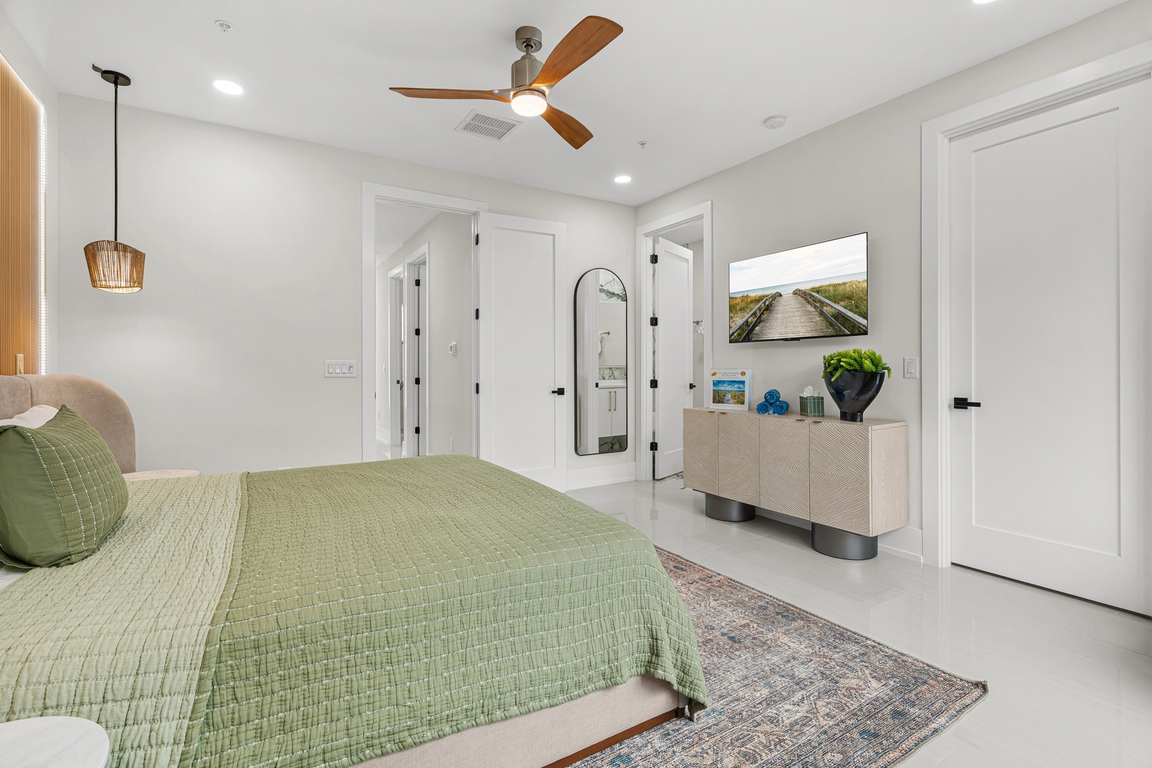 Unwind in your serene bedroom retreat, where coastal-inspired décor and soft green linens invite you to rest after a day of adventure.