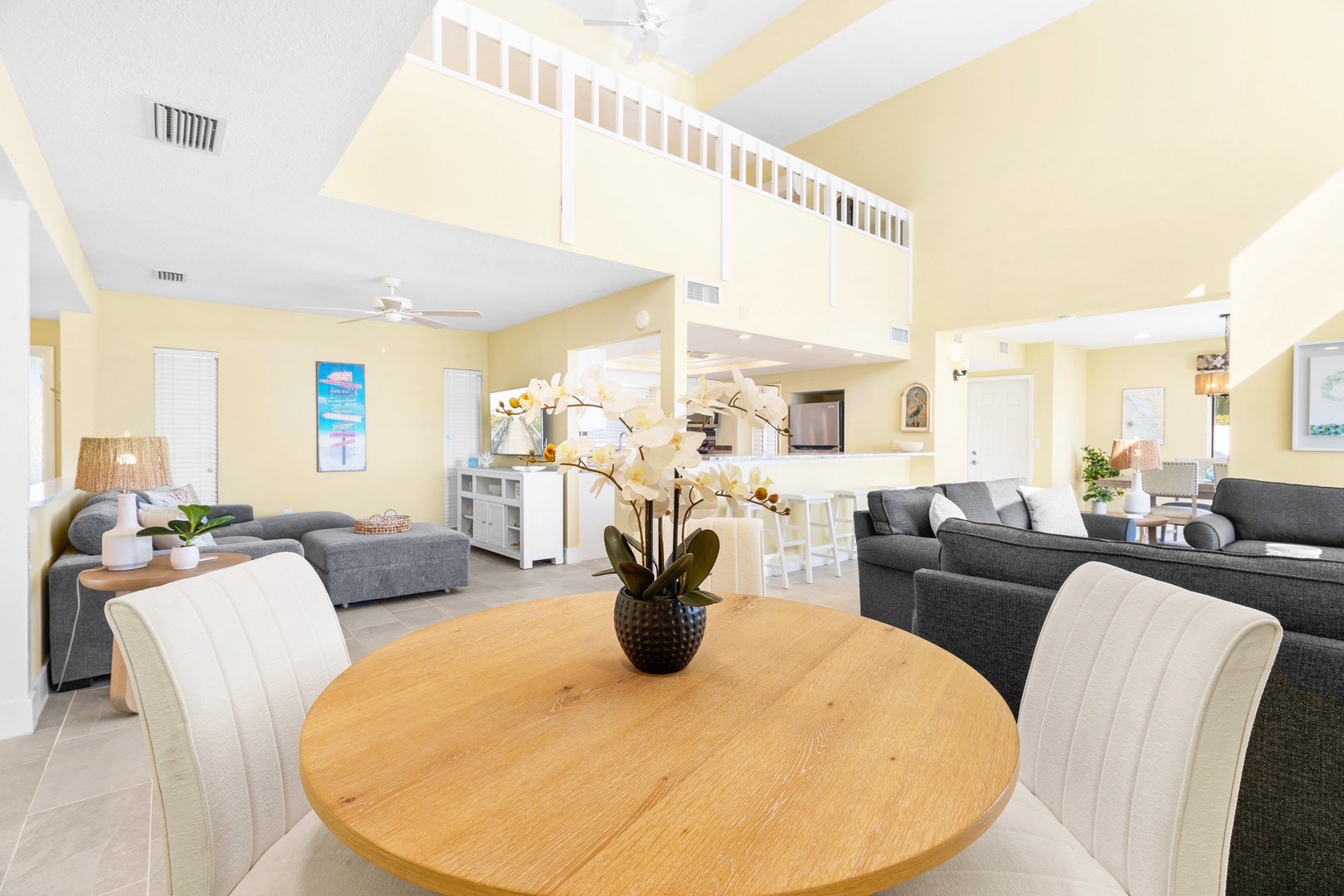 Relax in your open-plan living space where modern comfort meets coastal charm, featuring plush seating and a warm dining area perfect for gathering.