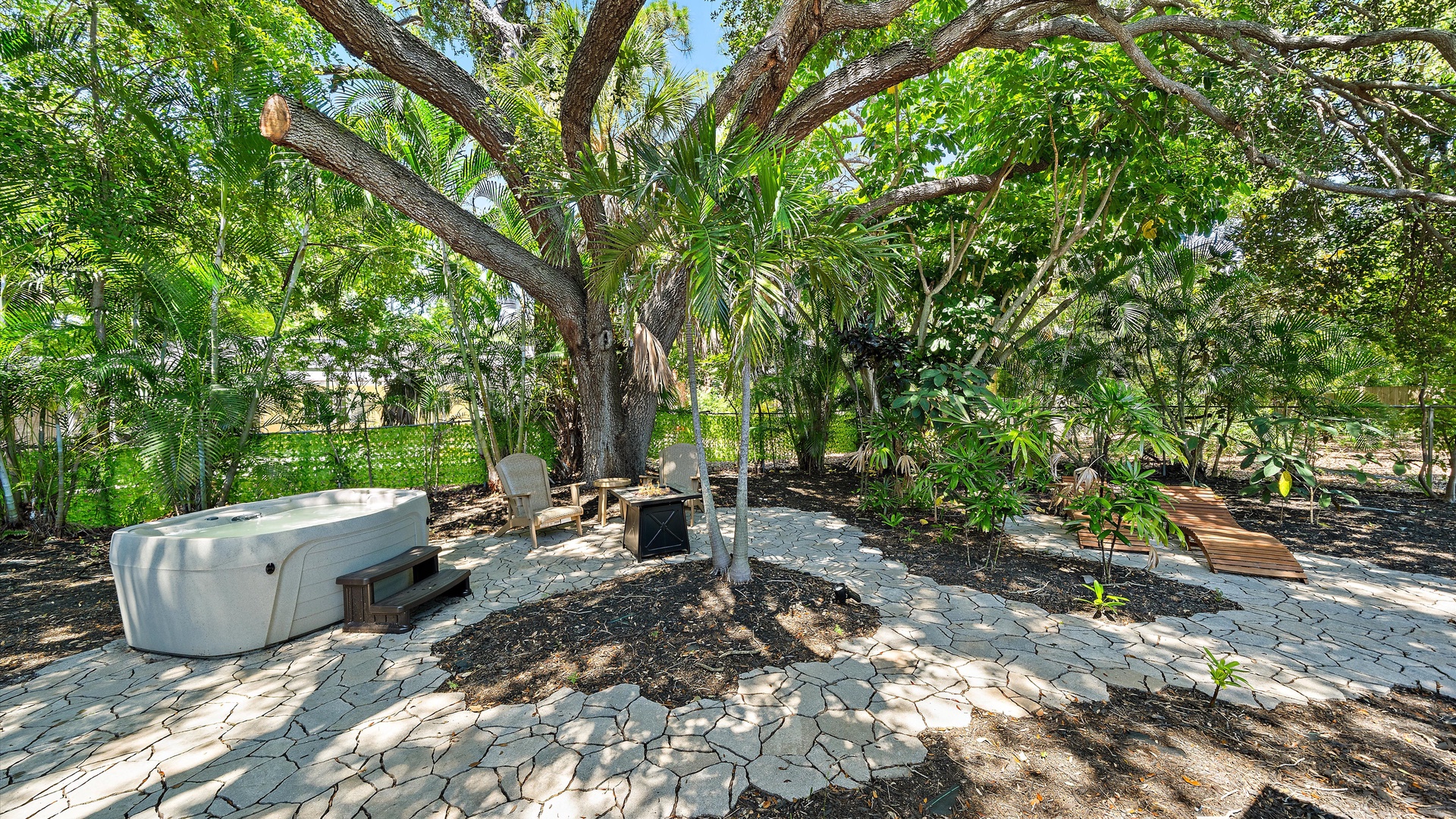 Discover your private tropical retreat beneath towering trees and swaying palms, where shaded seating invites you to unwind surrounded by lush greenery and natural tranquility.