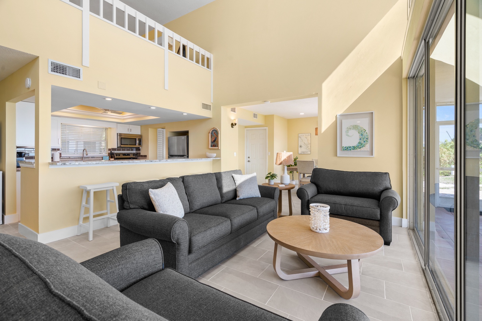 Relax in your spacious living room with comfortable seating, open kitchen views, and bright natural light streaming through sliding doors.