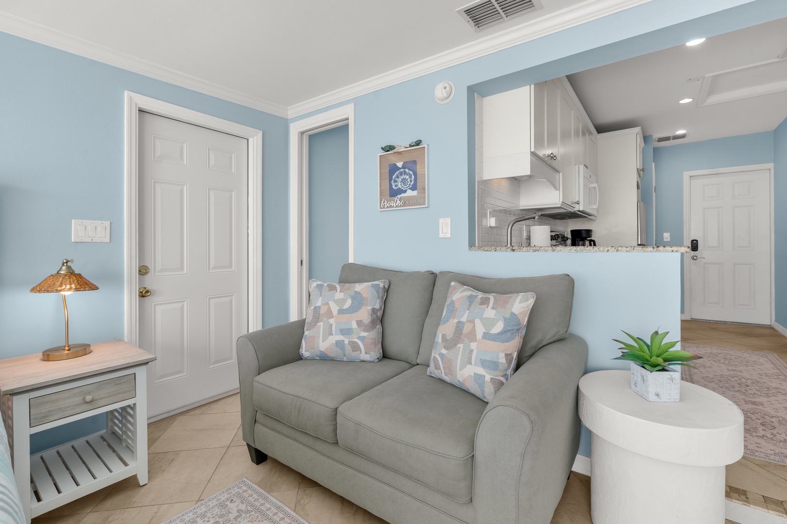 Relax in your coastal-inspired living space, where soft blue walls and comfortable seating create the perfect atmosphere for unwinding after your adventures.