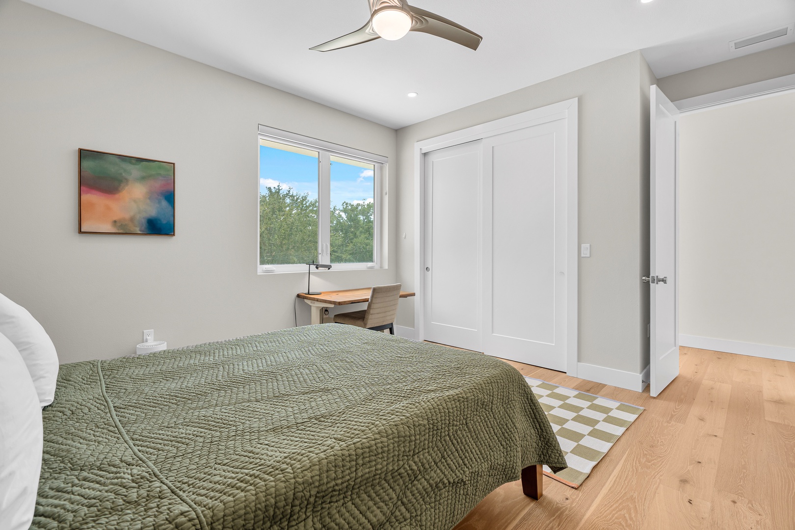 Wake up refreshed in this serene bedroom, where soft natural light spills through the window and a modern ceiling fan keeps you comfortable. The warm wood floors and calming palette make it your perfect retreat.