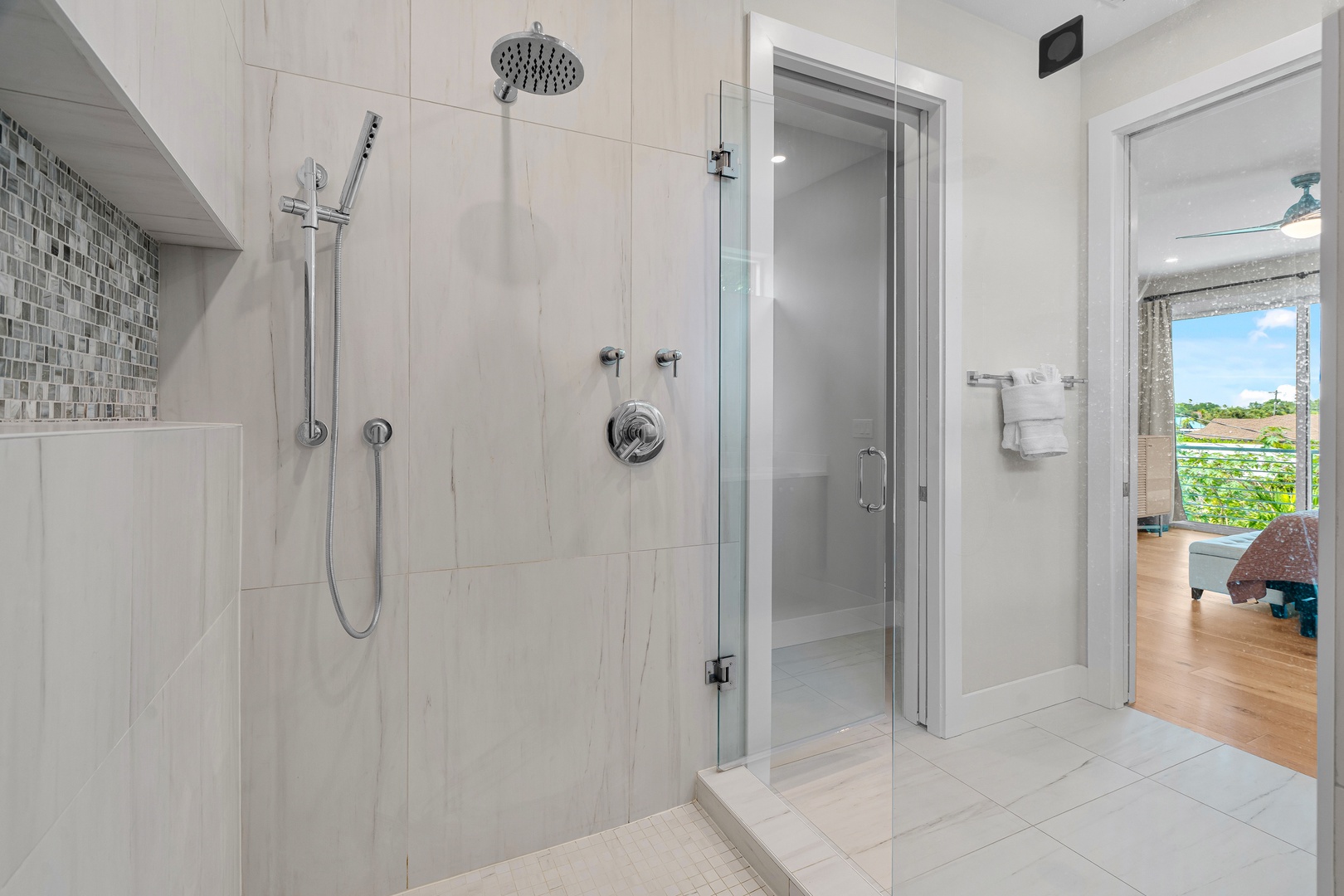 Bright, elegant marble finishes and a refreshing rainfall shower invite you to unwind after your day. The glass enclosure opens to a serene suite—your own private sanctuary.