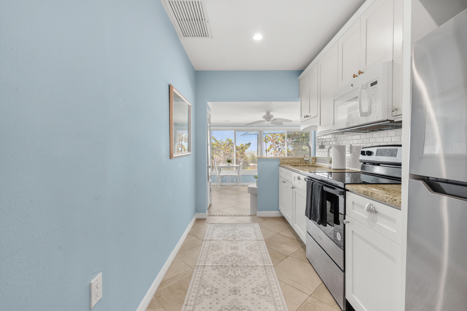 Your bright galley kitchen features stainless steel appliances and granite counters, with peaceful outdoor views through the window.