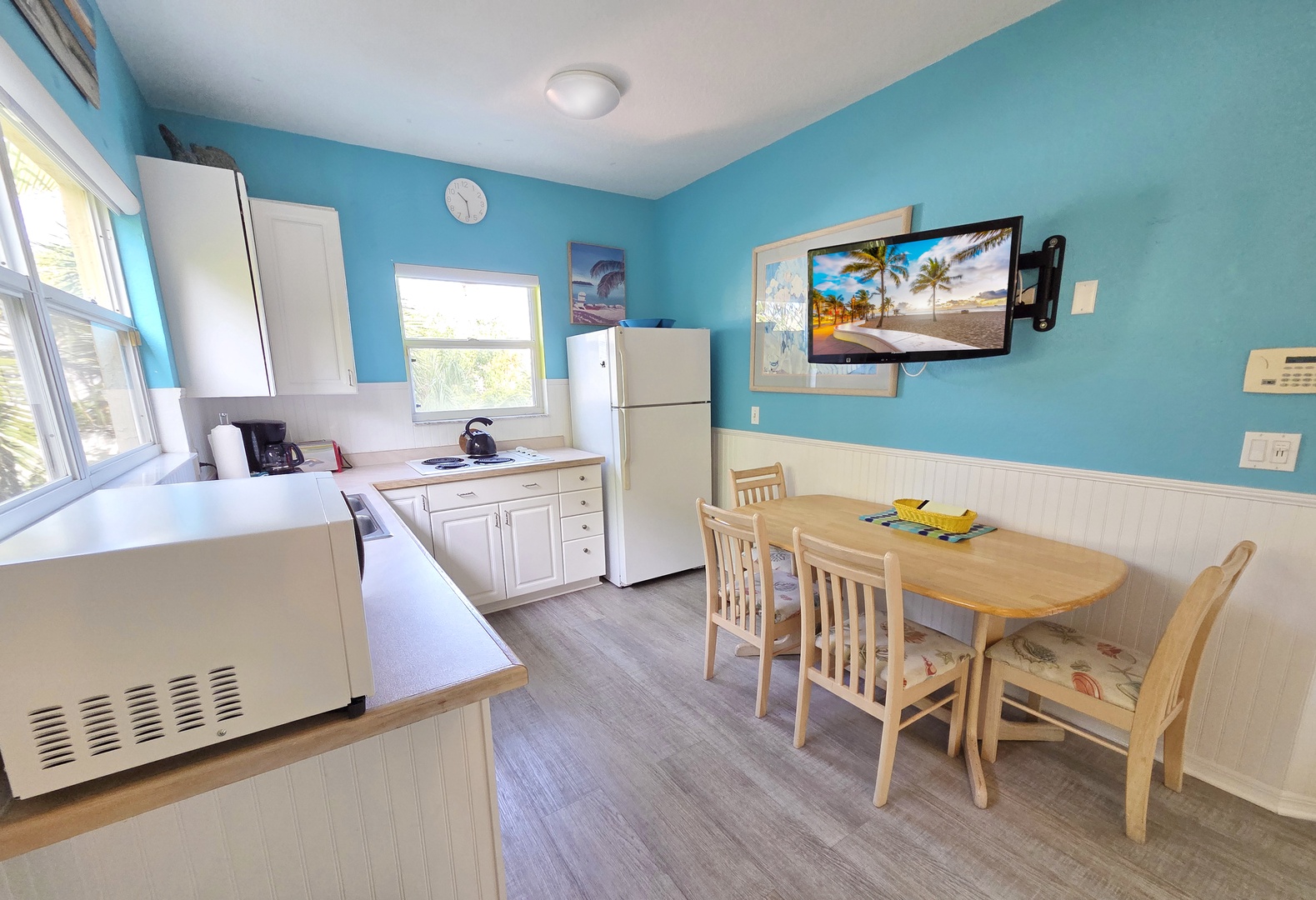 Your sunny kitchen awaits with light wood dining and bright windows that invite the day in. Gather around the table for breakfast, or unwind with a tropical drink while the coast beckons outside.