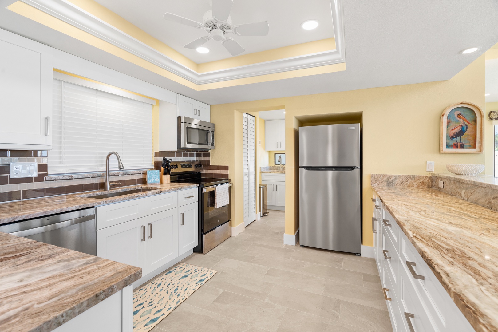 Your fully equipped kitchen awaits with granite countertops, stainless steel appliances, and elegant white cabinetry for memorable meal preparation.