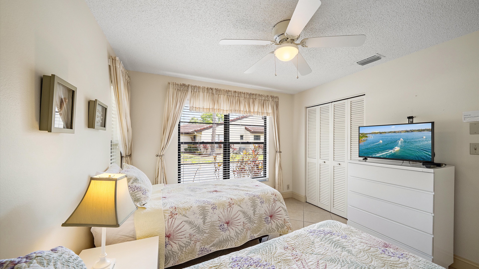 Unwind in this serene bedroom featuring soft linens, soothing coastal decor, and a ceiling fan to keep you comfortable during your stay.