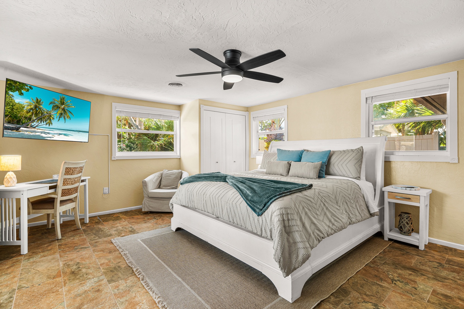 Wake up to lush tropical views through your bright windows, where soft breezes from the ceiling fan keep you comfortable. Settle into the inviting king bed after a day of exploring, and unwind with the calming coastal palette surrounding you.