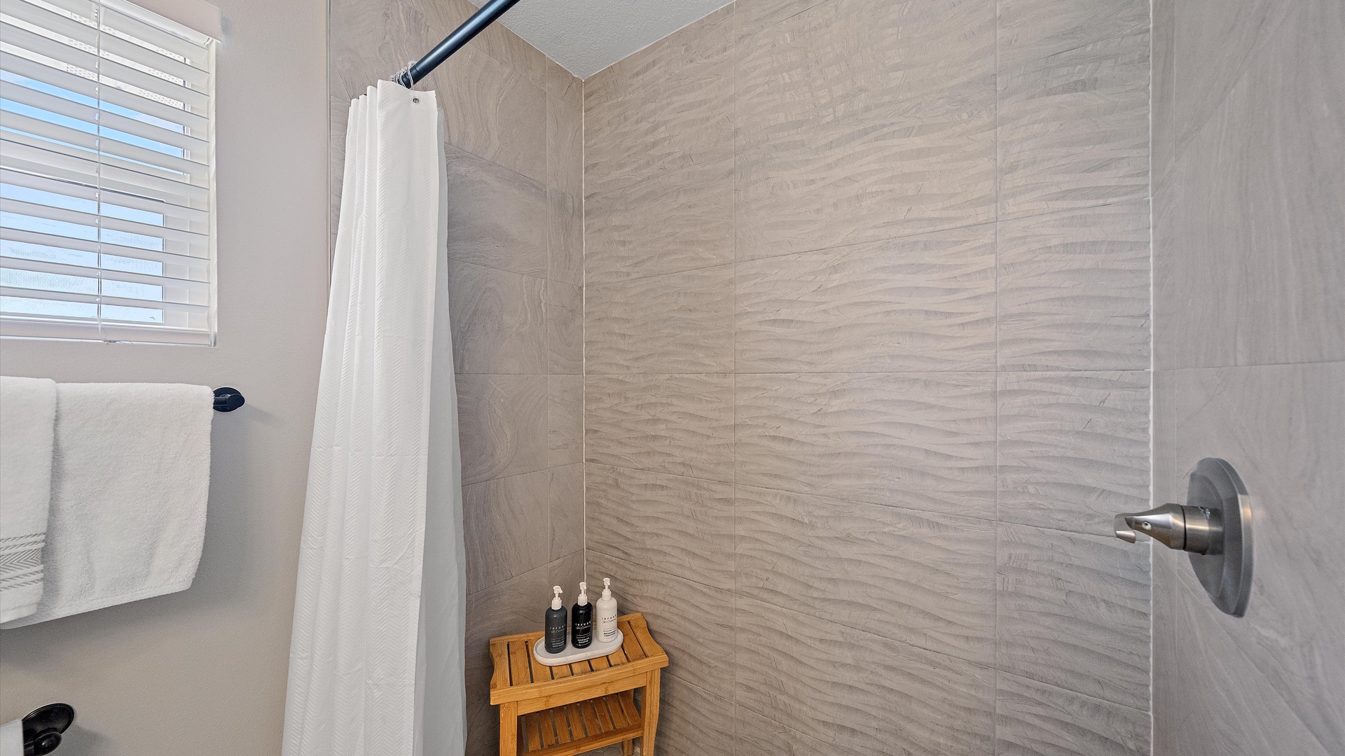 Step into your private spa-like shower, where sleek modern tiles and a rainfall showerhead create a serene retreat after a day of adventure.