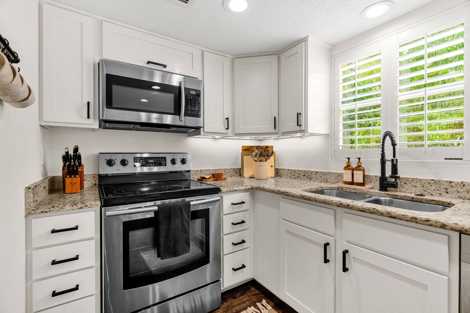 Your fully equipped kitchen awaits with stainless appliances, granite counters, and bright natural light—perfect for preparing meals during your stay.