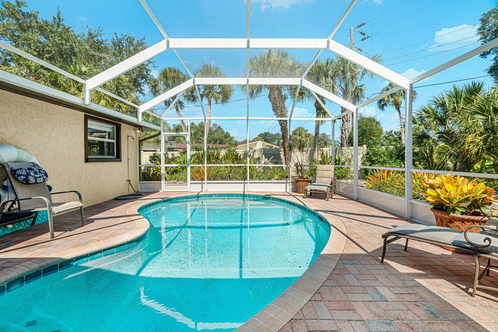 Step into your private paradise—a sparkling screened-in pool surrounded by lush palms and tropical plants, perfectly framed by Florida sunshine. Your own oasis awaits for endless relaxation.