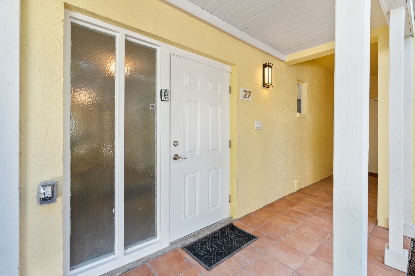 Step into your welcoming retreat through this cheerful entrance with warm yellow walls and charming tile floors that set the tone for relaxation.