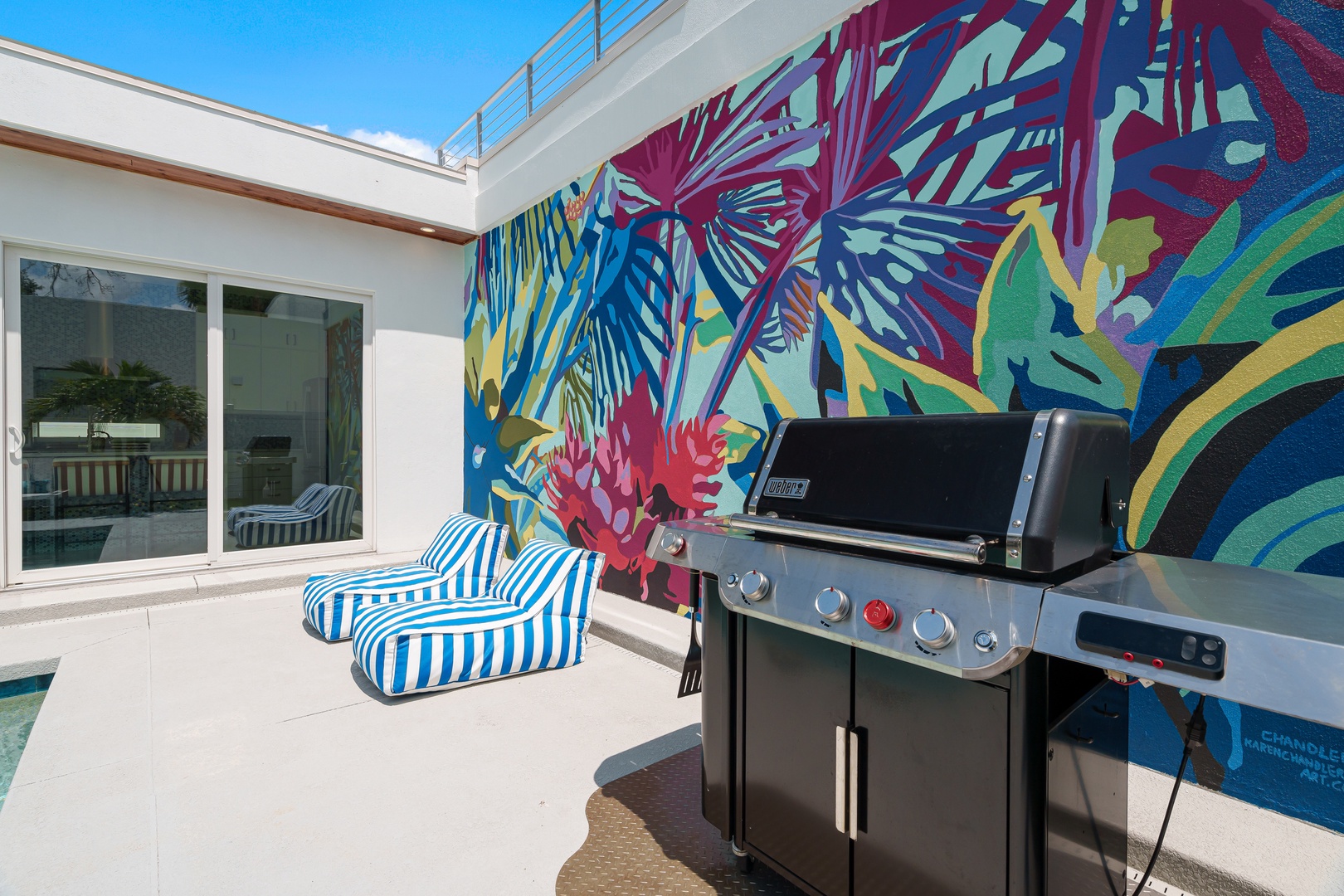 A vibrant tropical mural brings artistic flair to your private outdoor terrace, where you can fire up the grill and lounge in comfort under open skies.