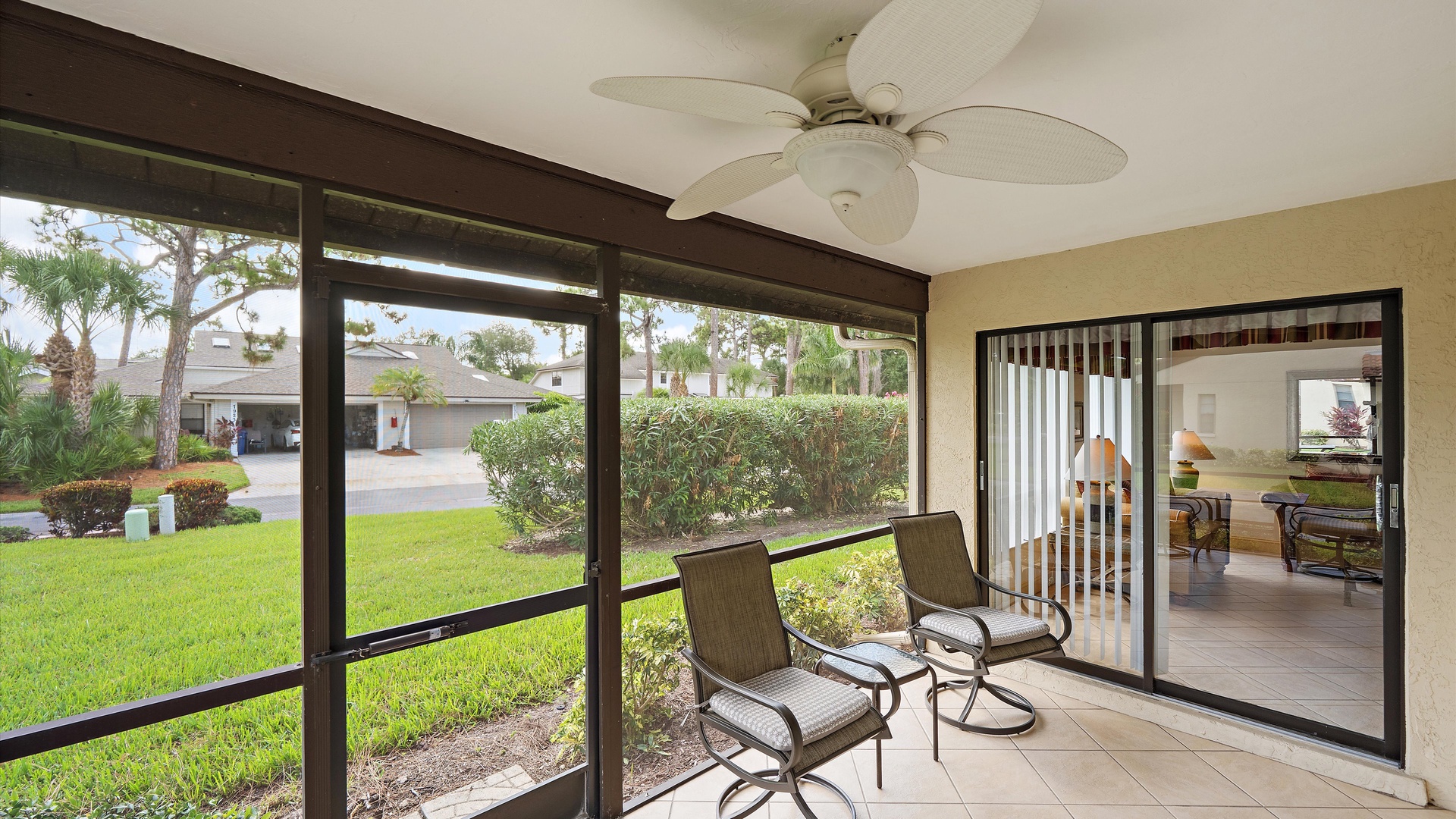 Relax in your screened lanai, where a ceiling fan keeps you cool and garden views frame your private outdoor retreat.