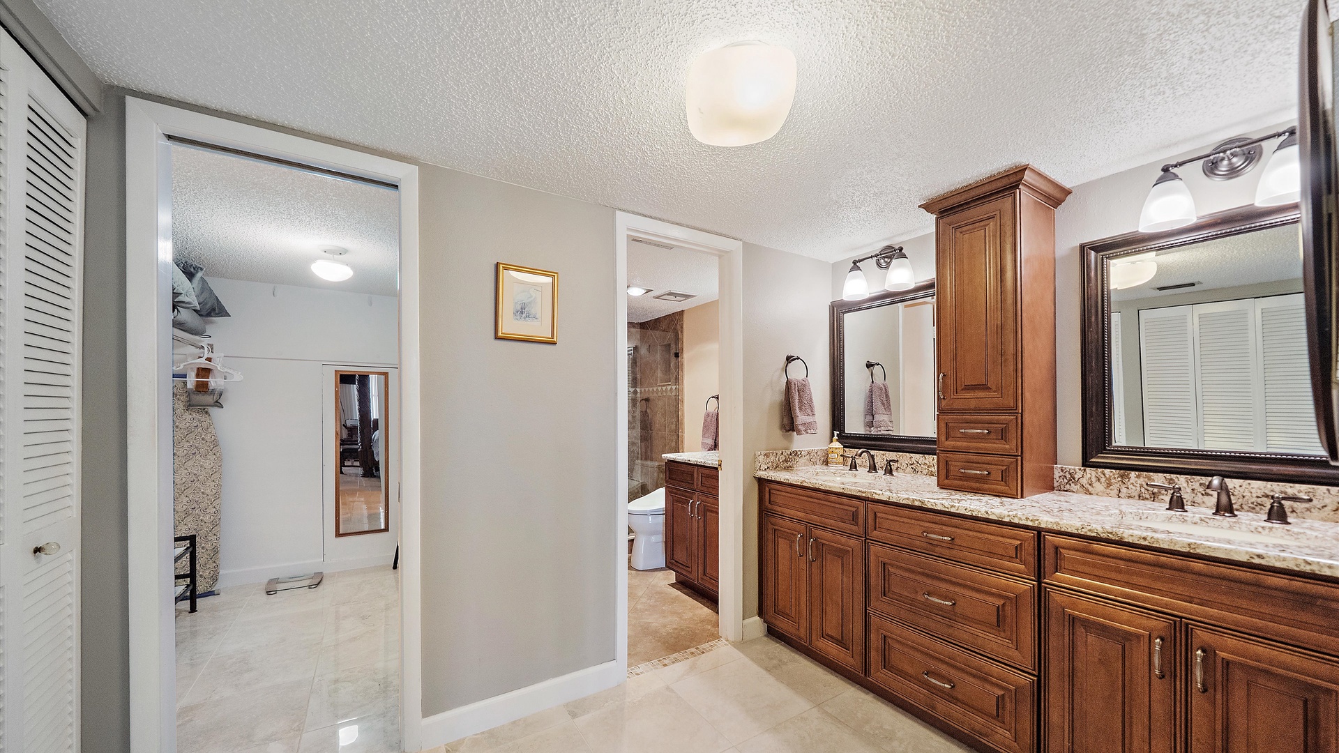 Luxurious dual-sink master bathroom with elegant granite counters and rich wood cabinetry for your comfort.