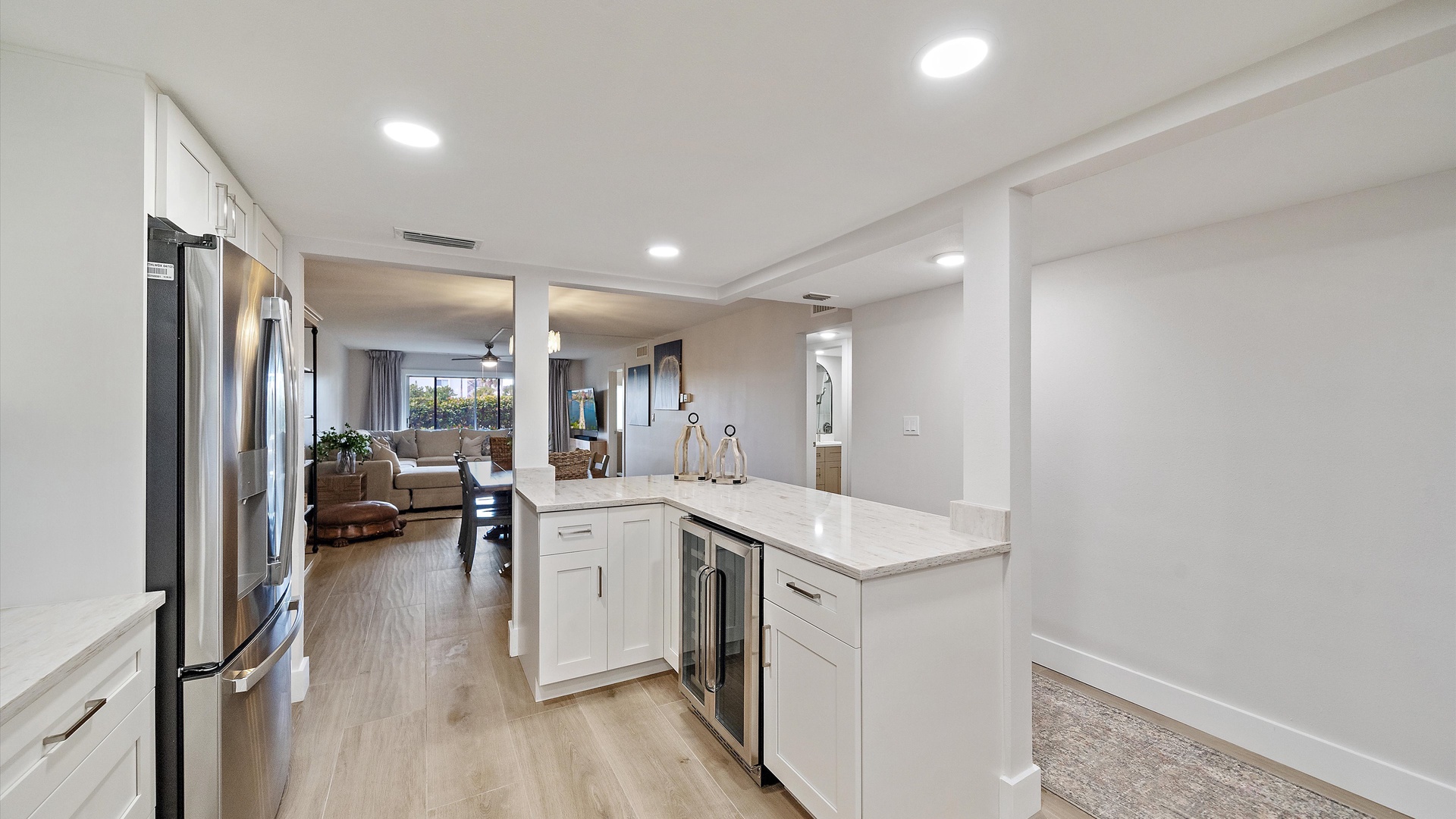 Your modern kitchen flows seamlessly into the bright living area, featuring stainless steel appliances and white quartz counters perfect for meal prep.