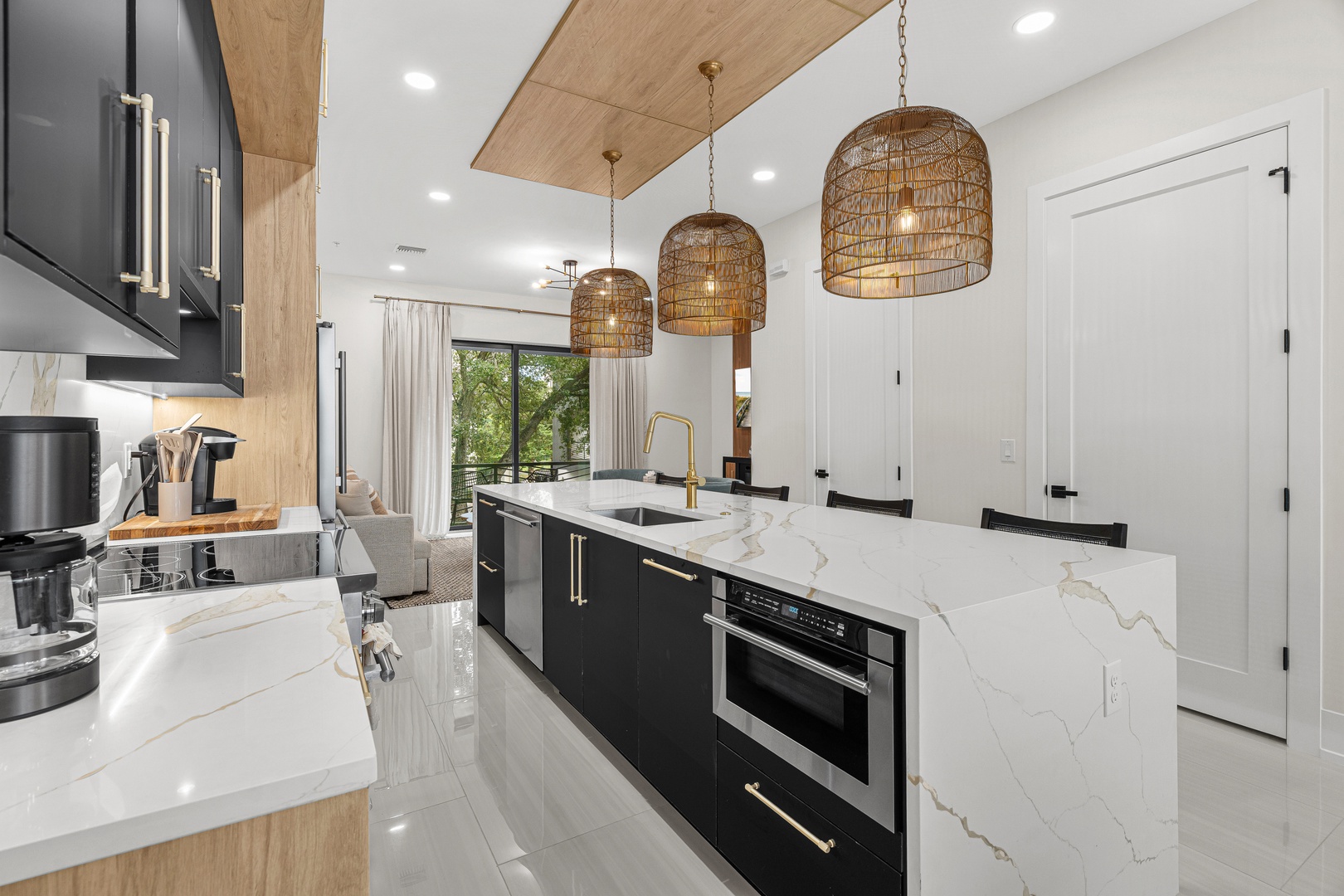 Step into your sleek, modern kitchen where natural light pours through the window, illuminating beautiful marble countertops and stylish woven pendant lights overhead—perfect for cooking and entertaining.