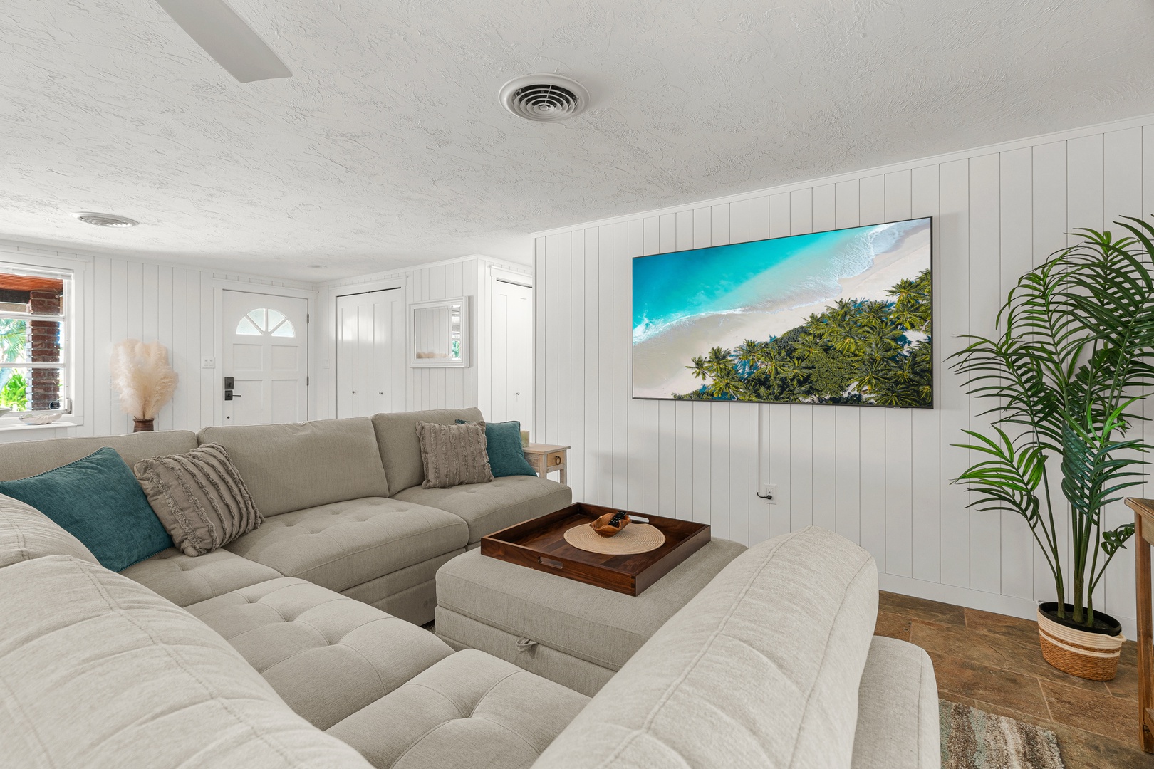 Unwind in your spacious coastal living room with plush sectional seating and natural light streaming through the windows—perfect for cozy evenings or gathering with friends.