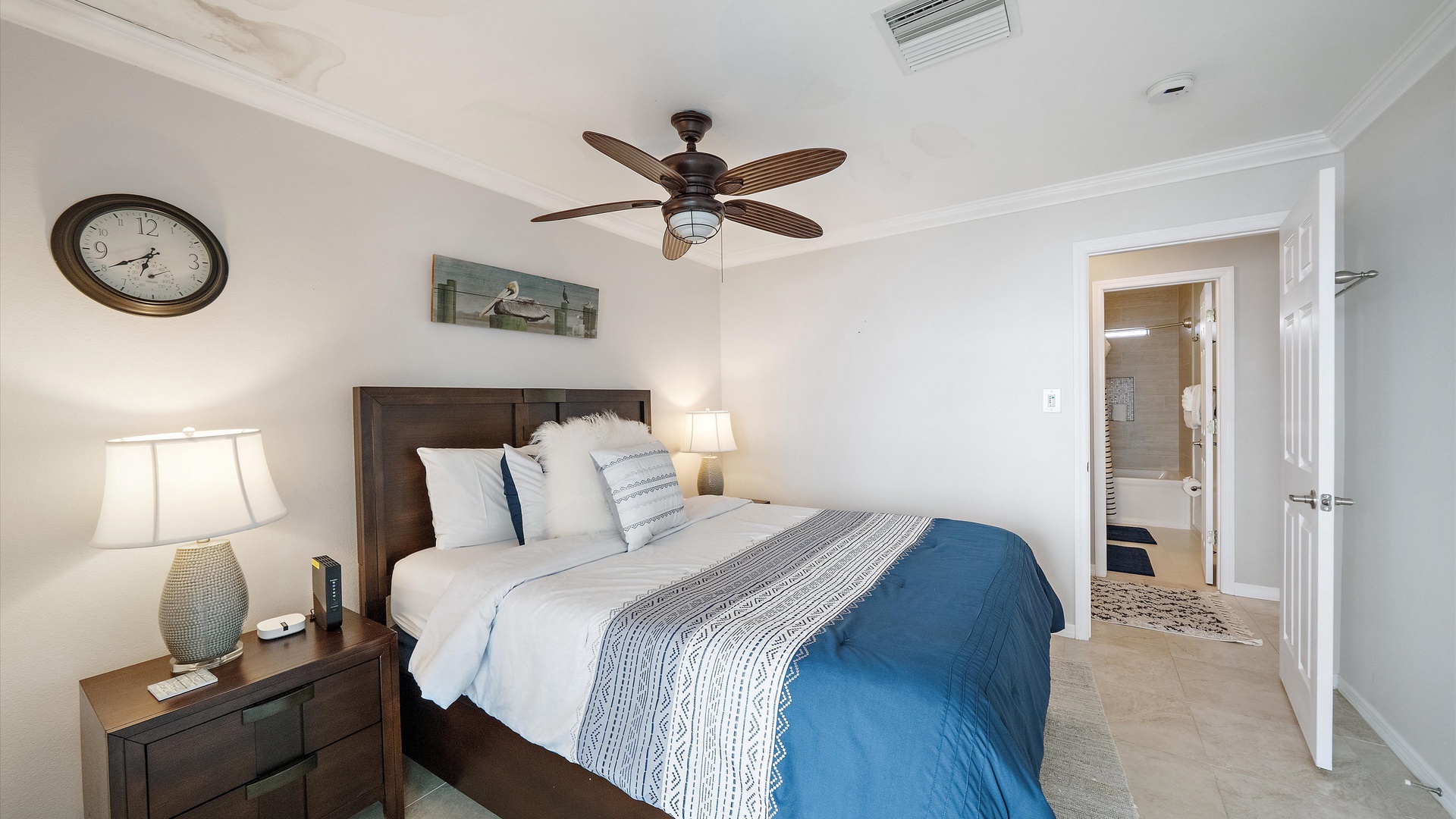Blue-and-white bedding and a warm wood headboard give the queen bedroom a classic coastal look. A comfortable second retreat with the same relaxed feel as the rest of the home.
