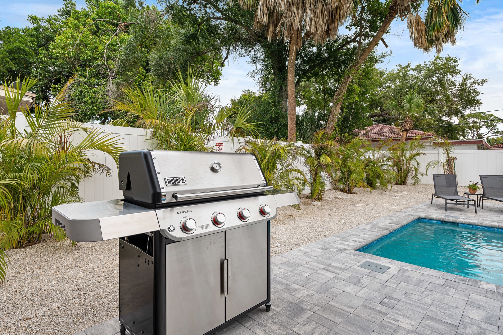 Fire up the grill and soak up the sun in your private backyard oasis, complete with a sparkling pool and lush tropical landscaping perfect for outdoor entertaining.