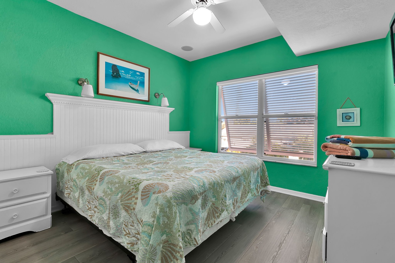 Wake up refreshed in your cheerful bedroom, where vibrant turquoise walls and coastal touches set a relaxed vacation tone. The plush bed promises restful nights while soft breezes drift through your window.