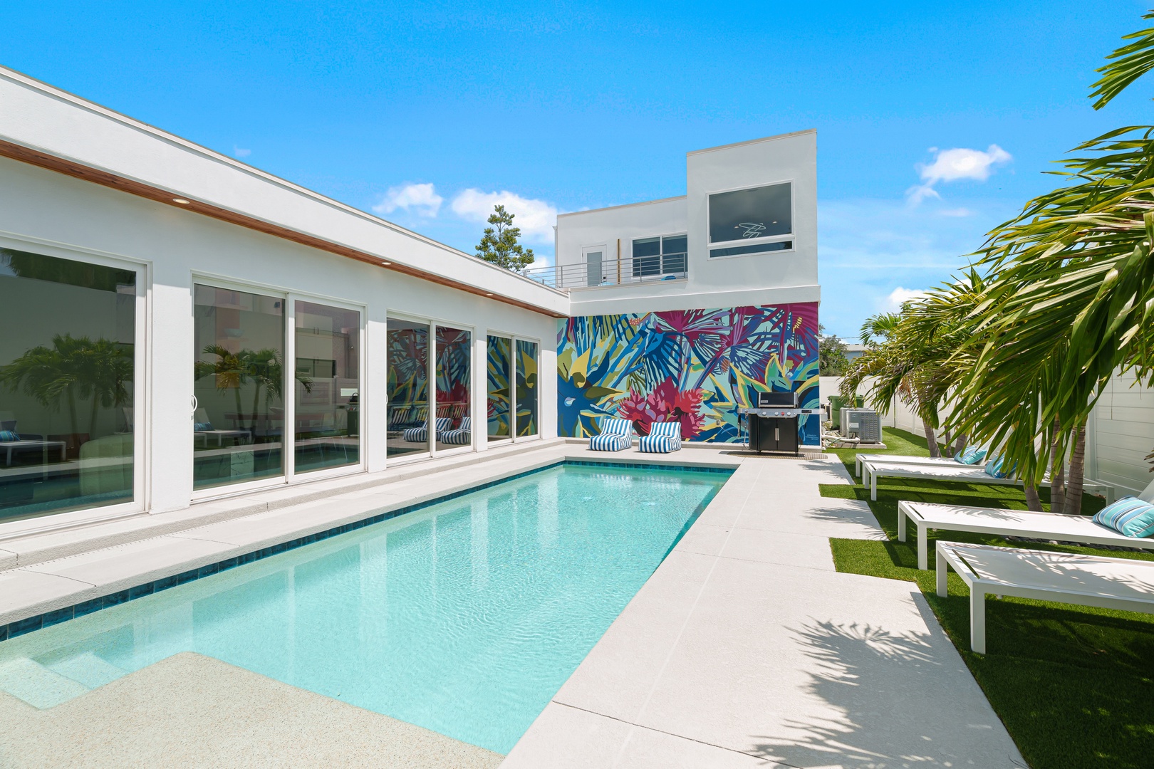 Picture yourself lounging by your private pool, surrounded by vibrant tropical art and swaying palms. This sun-drenched oasis offers the perfect retreat for relaxation and unforgettable moments.