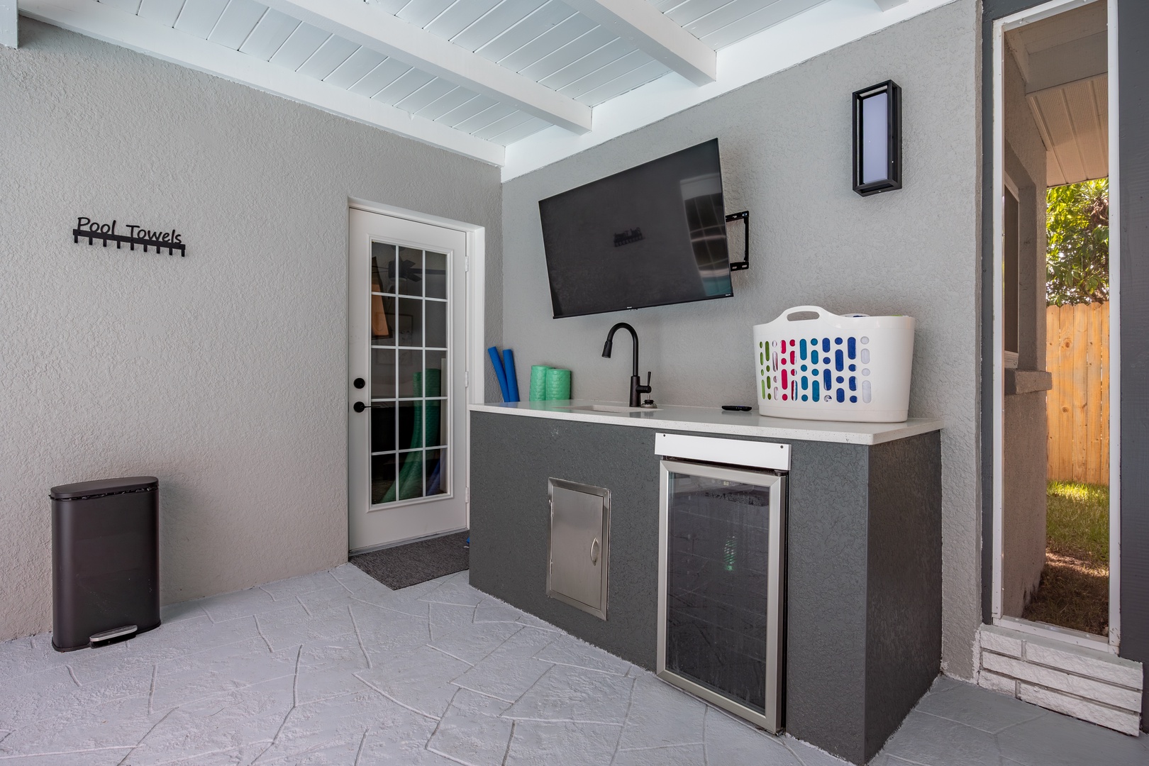 Your private outdoor kitchen awaits with a sleek counter, sink, and mini-fridge—perfect for poolside refreshments and easy entertaining.