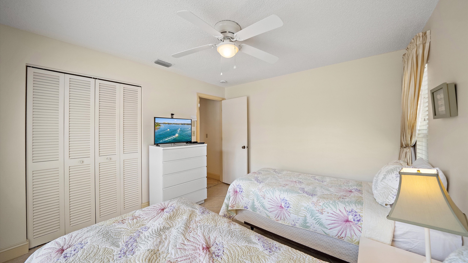 Your restful retreat features two cozy beds, a gentle ceiling fan, and a TV for entertainment—perfect for relaxing after a day of adventure.