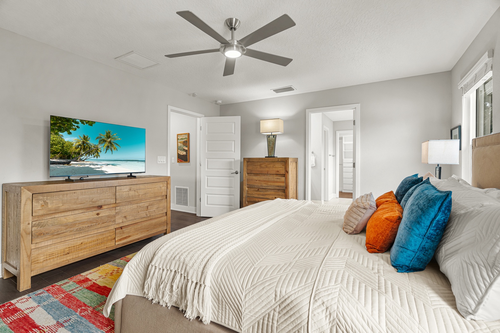 Unwind in the primary king bedroom with hotel-style linens, ensuite bathroom and soaking tub, plush towels, and Smart TV.