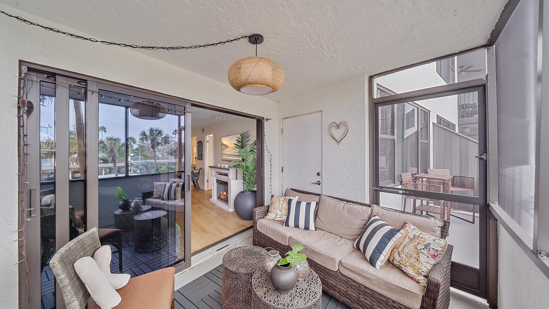 Relax in your bright enclosed balcony with comfortable seating, enjoying the seamless flow to your main living area through floor-to-ceiling glass doors.