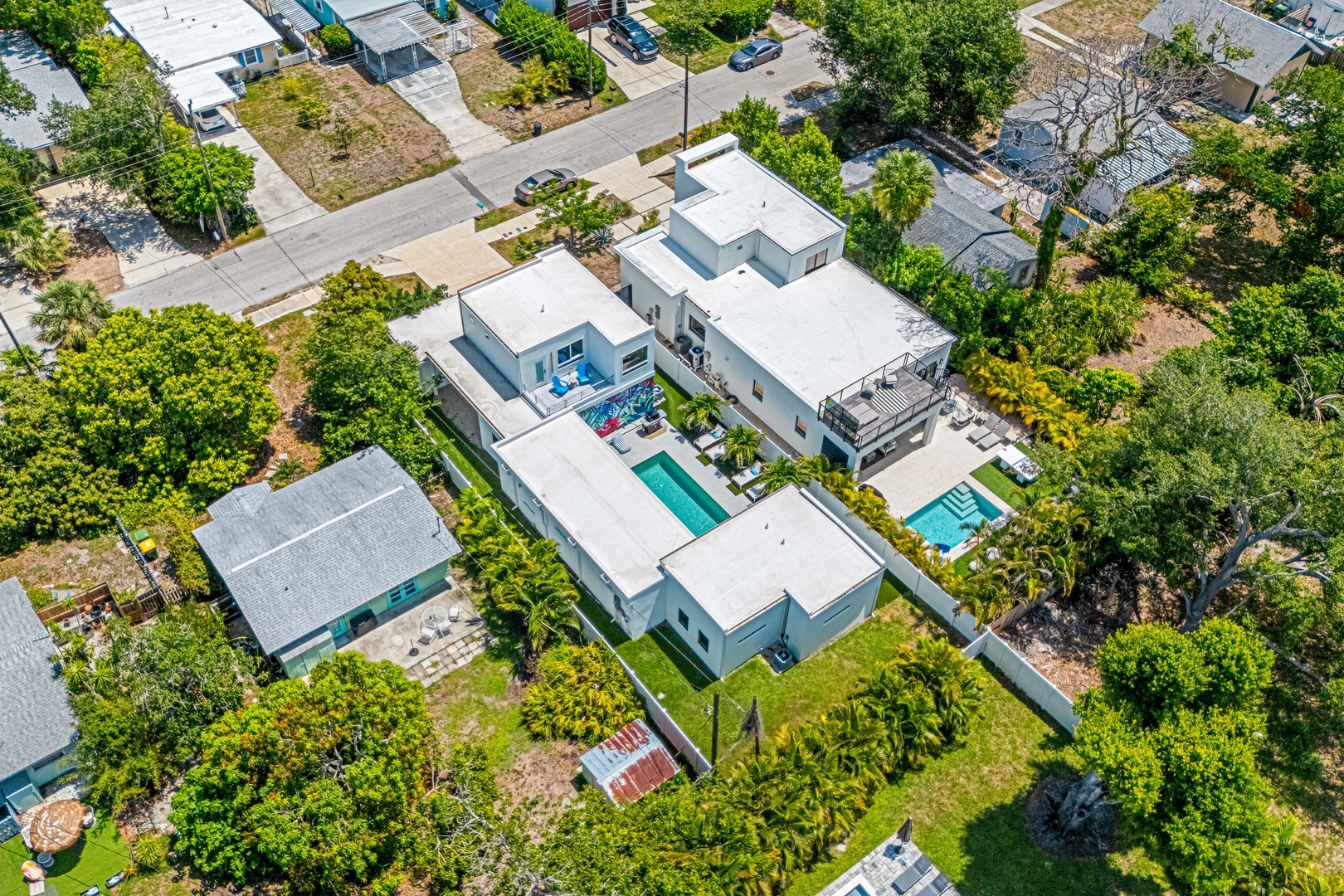 Aerial view of home nestled in a quiet, tree-lined neighborhood. The property surrounded by lush greenery and spacious outdoor areas perfect for relaxation.