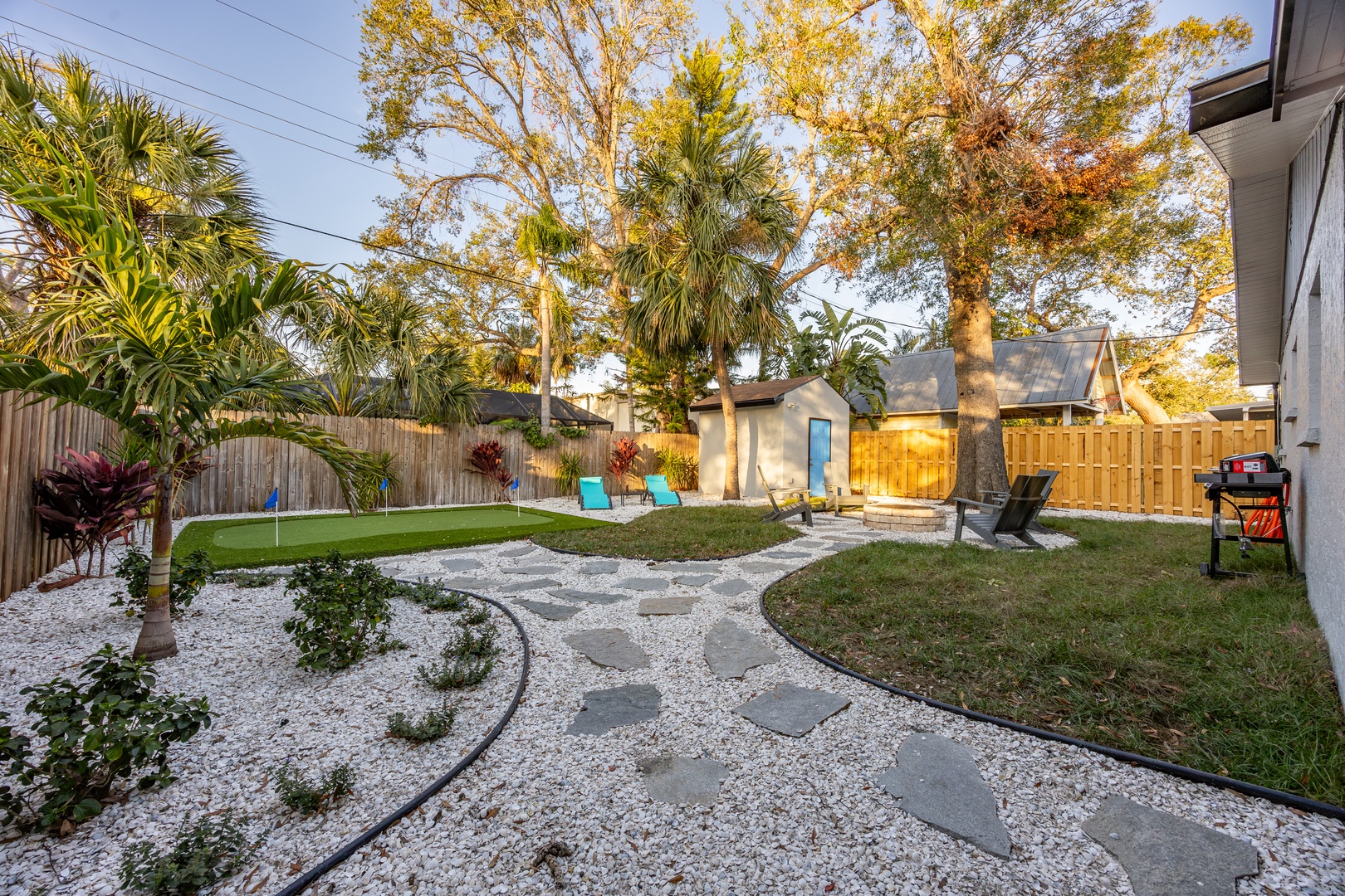 Your private backyard oasis awaits with lush tropical landscaping, cozy seating areas, and a charming shed for extra storage or workspace needs.