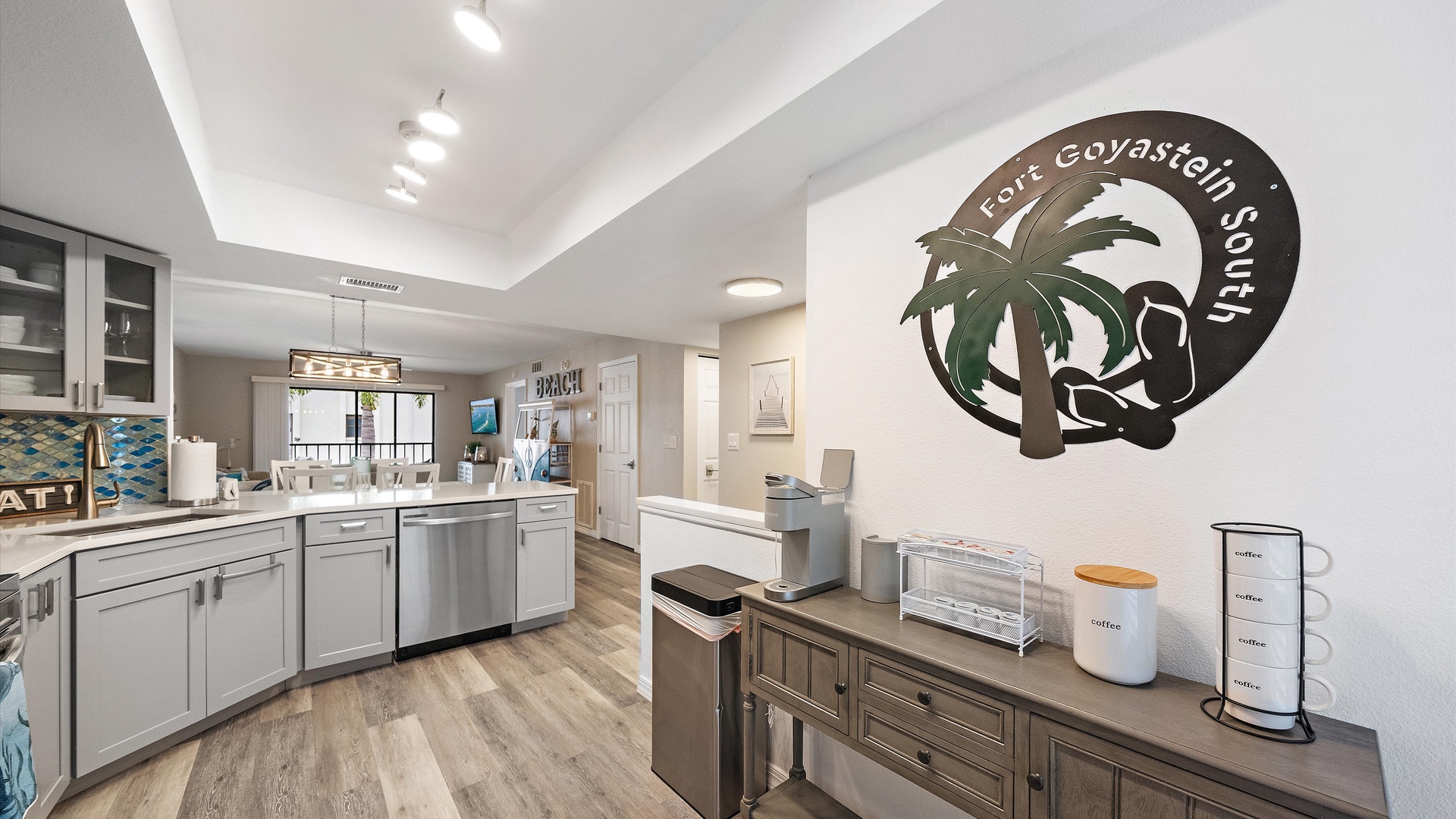 Your open-concept kitchen and living space features modern cabinetry, sleek appliances, and a coastal-inspired design, creating an inviting atmosphere perfect for gathering after a day at the beach.