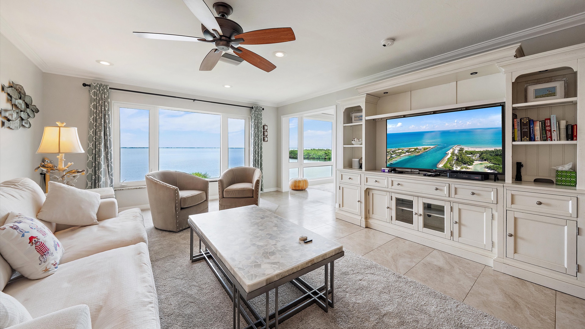 Sarasota Bay sets the scene at Windward Bay Penthouse Escape. Stretch out in the light-filled living room, with beautiful blue water beyond the sunroom windows and a peaceful Longboat Key afternoon ahead.