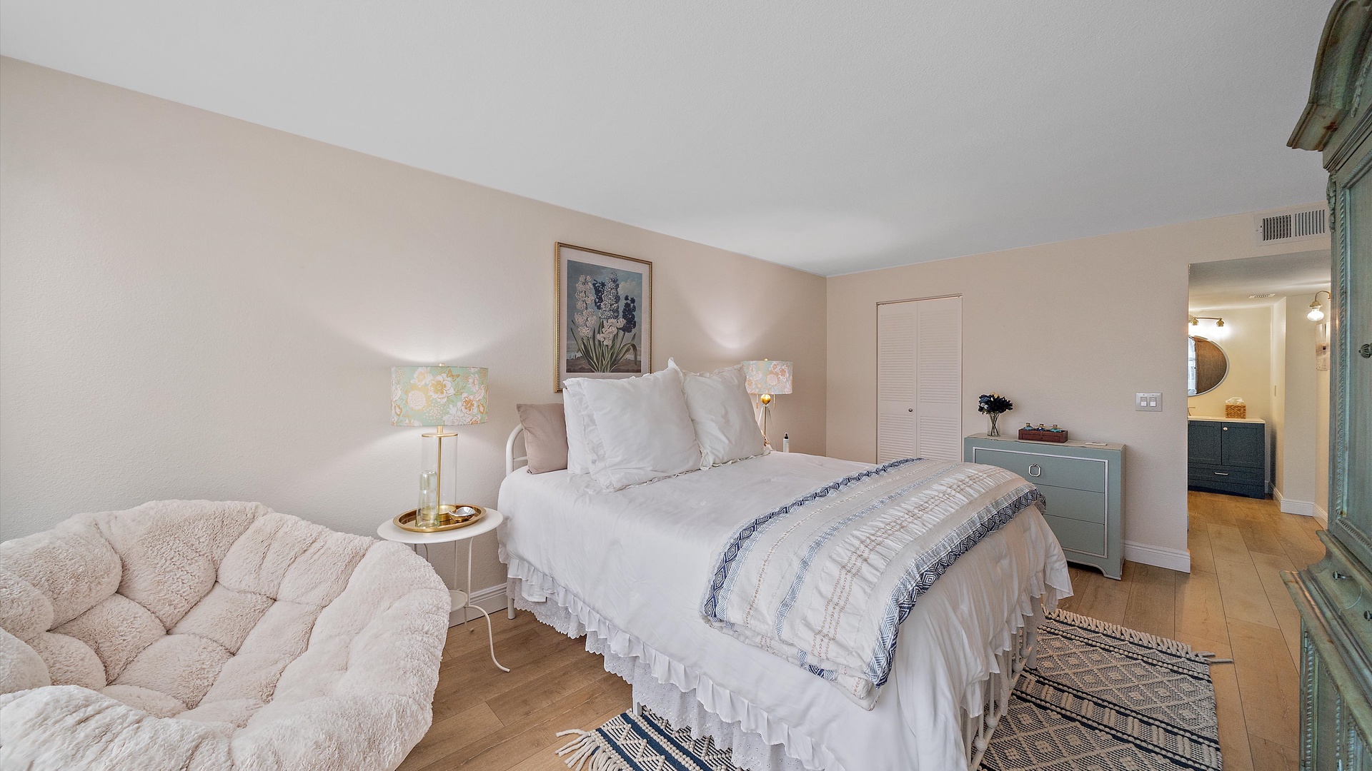 Sink into plush comfort in your serene bedroom, featuring a cozy reading chair and elegant furnishings for the perfect night's rest.