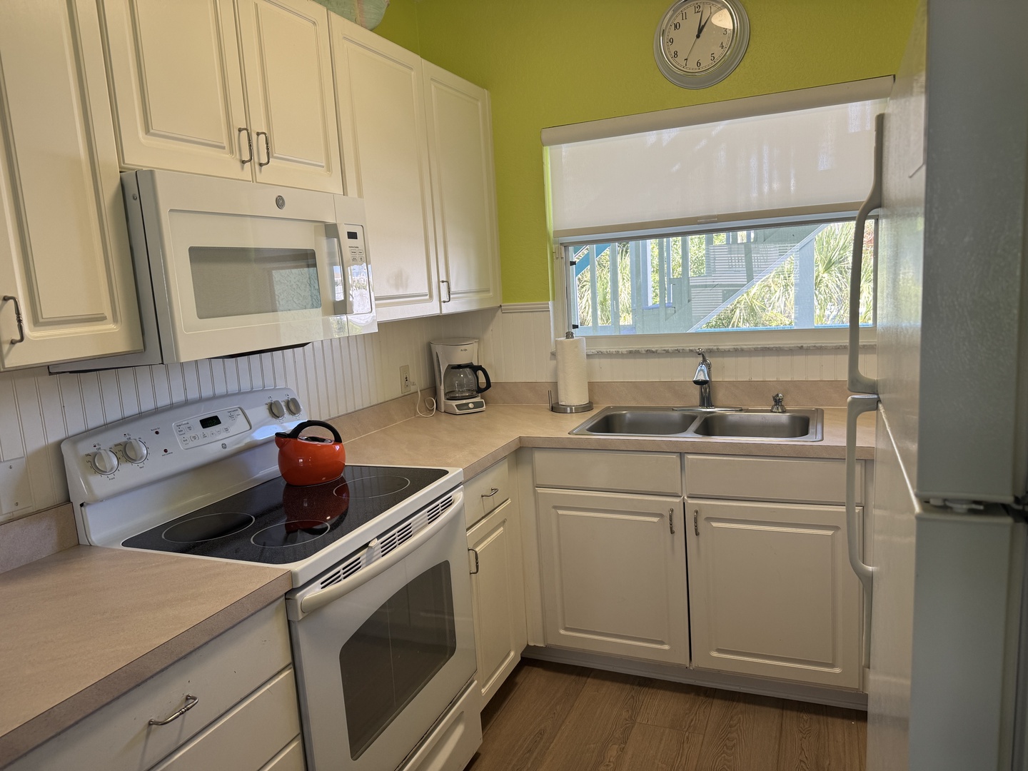 Your bright, fully equipped kitchen has everything you need, from a sleek stove and microwave to palm tree views through the window—perfect for whipping up vacation meals in comfort.