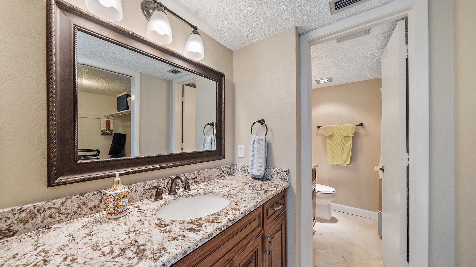Your elegant bathroom features granite countertops, warm lighting, and thoughtful touches that make your morning routine feel luxurious and relaxing.