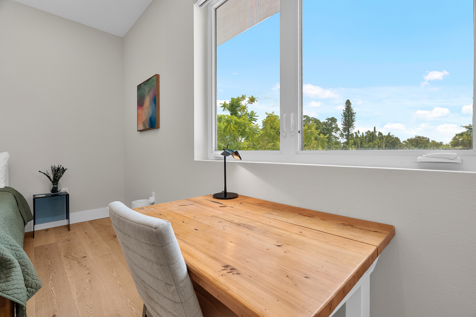 Work from your sunny desk overlooking lush greenery and blue skies—your perfect quiet corner for focus or inspiration awaits.