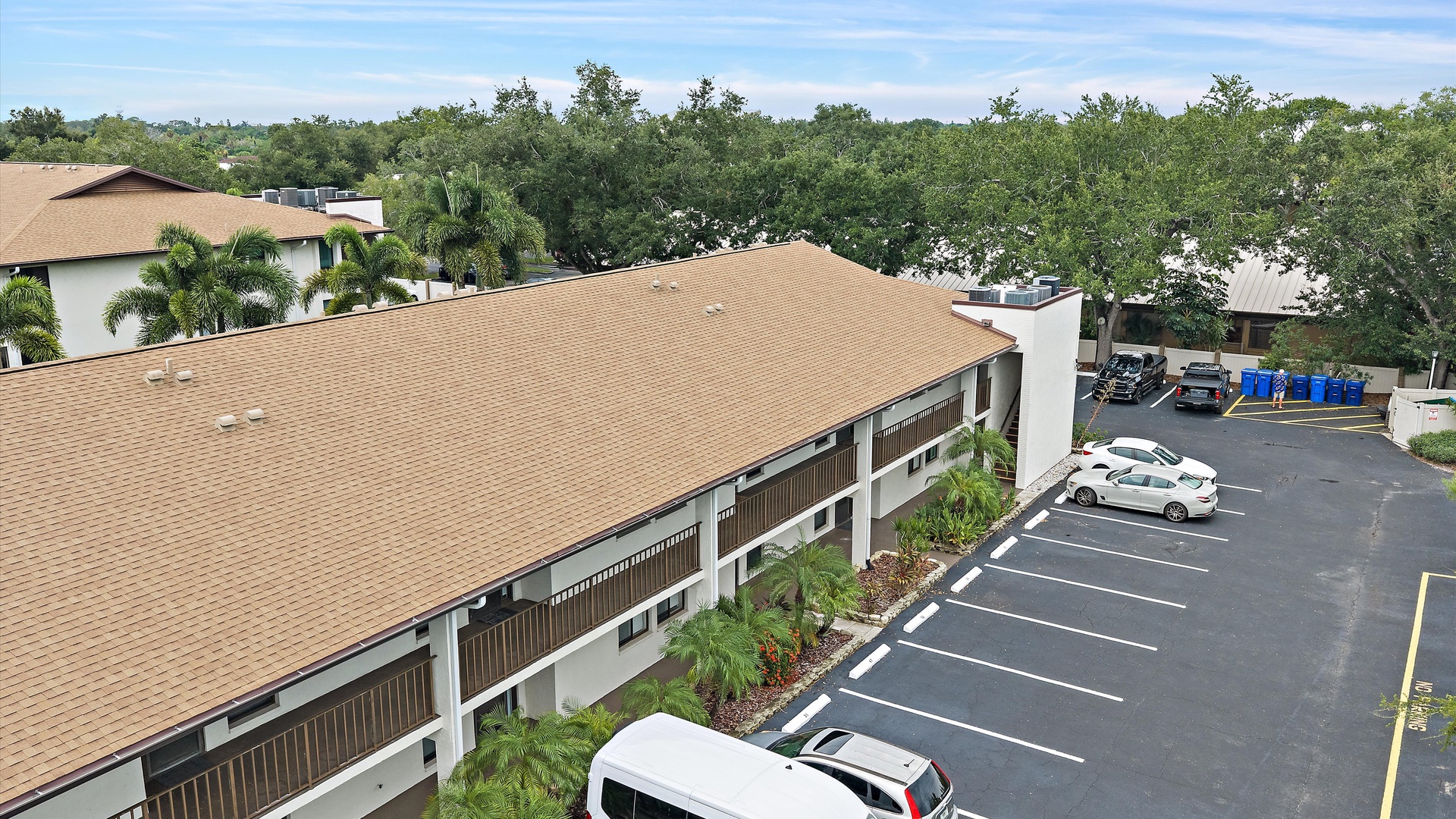 The property sits nestled among lush greenery and palm trees, offering convenient parking and easy access to your vacation retreat.
